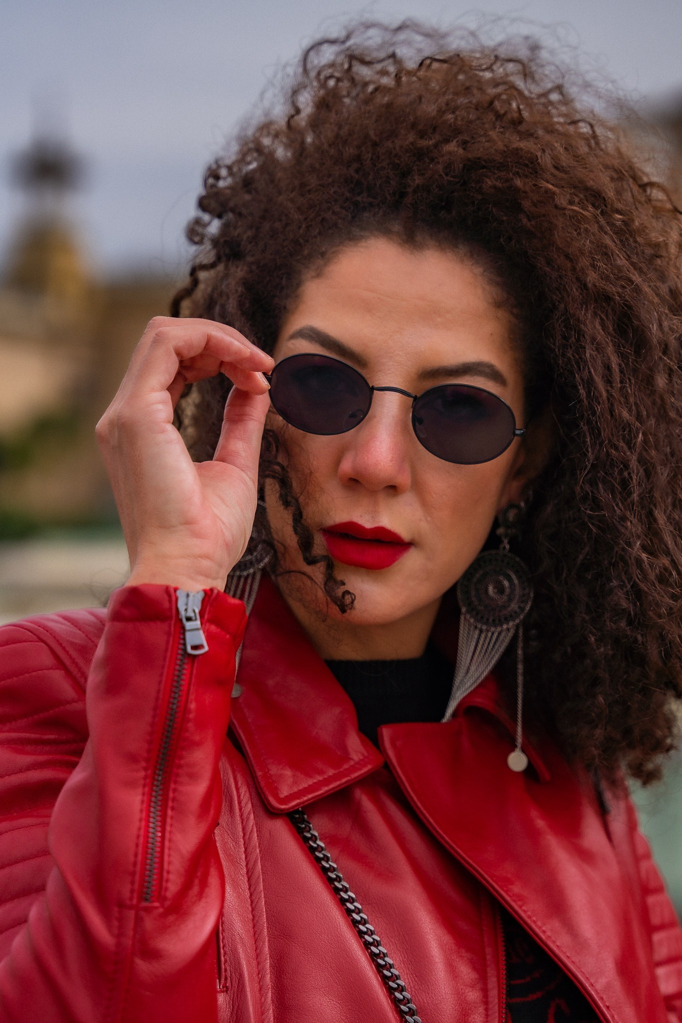 Modelo con chaqueta roja y gafas de sol redondas