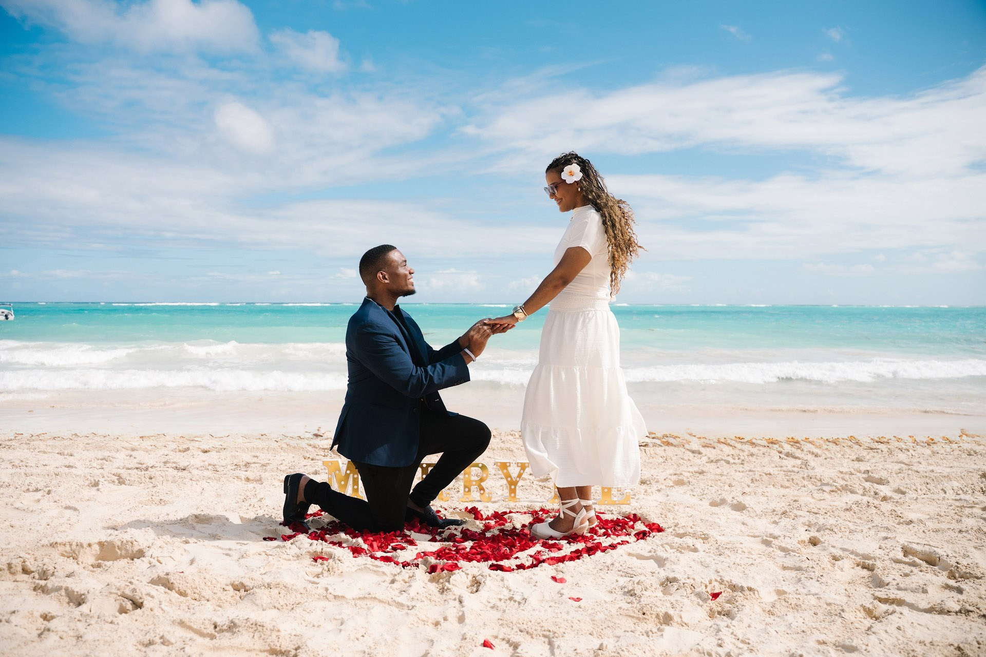 Romantic beach proposal in Punta Cana with heart of rose petals and small marry me letters
