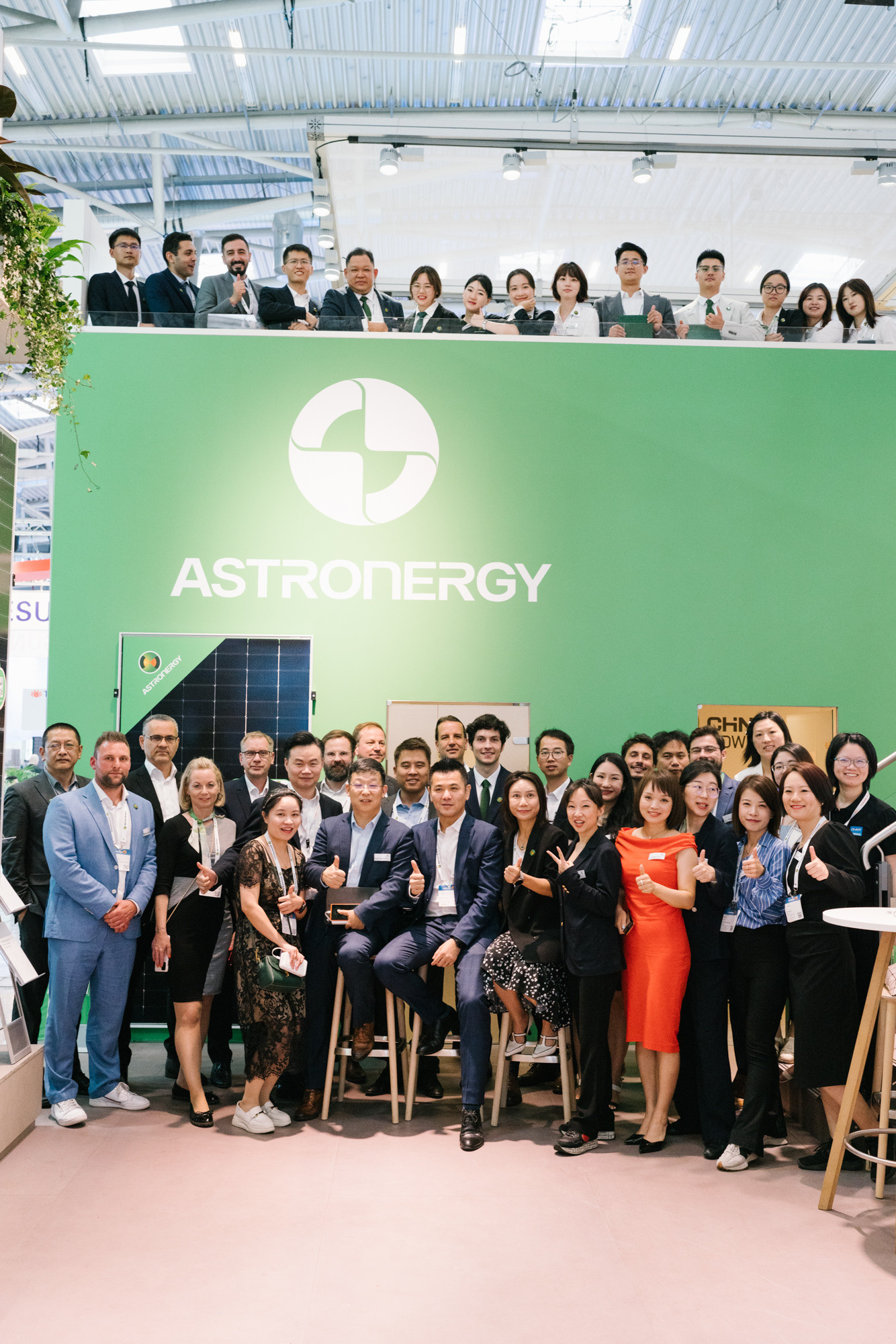 Large group portrait in front of the brand wall at a Milan trade show
