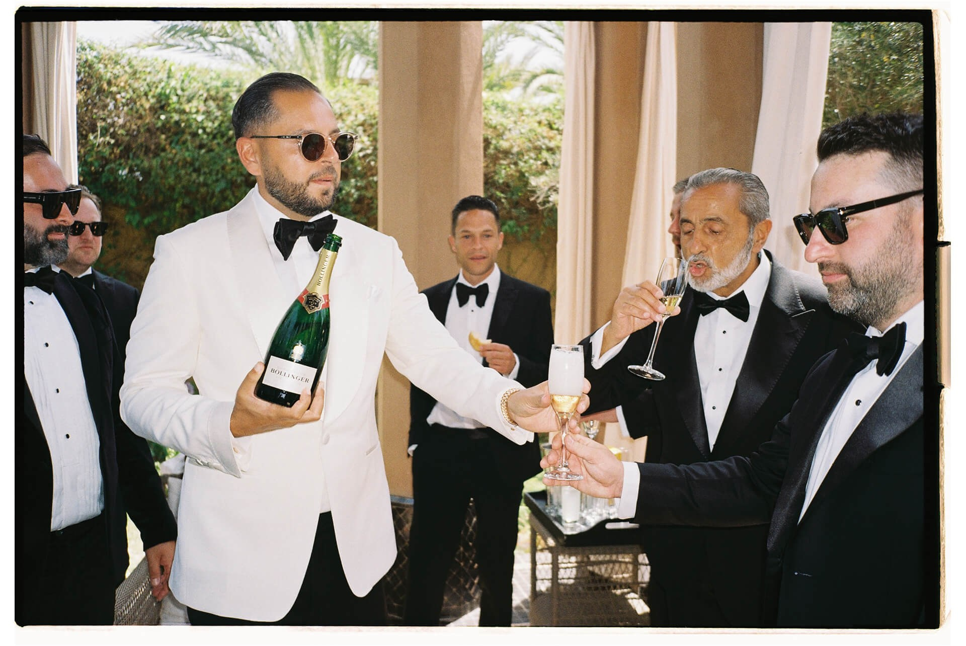 Groom pouring champagne during Morocco wedding preparation
