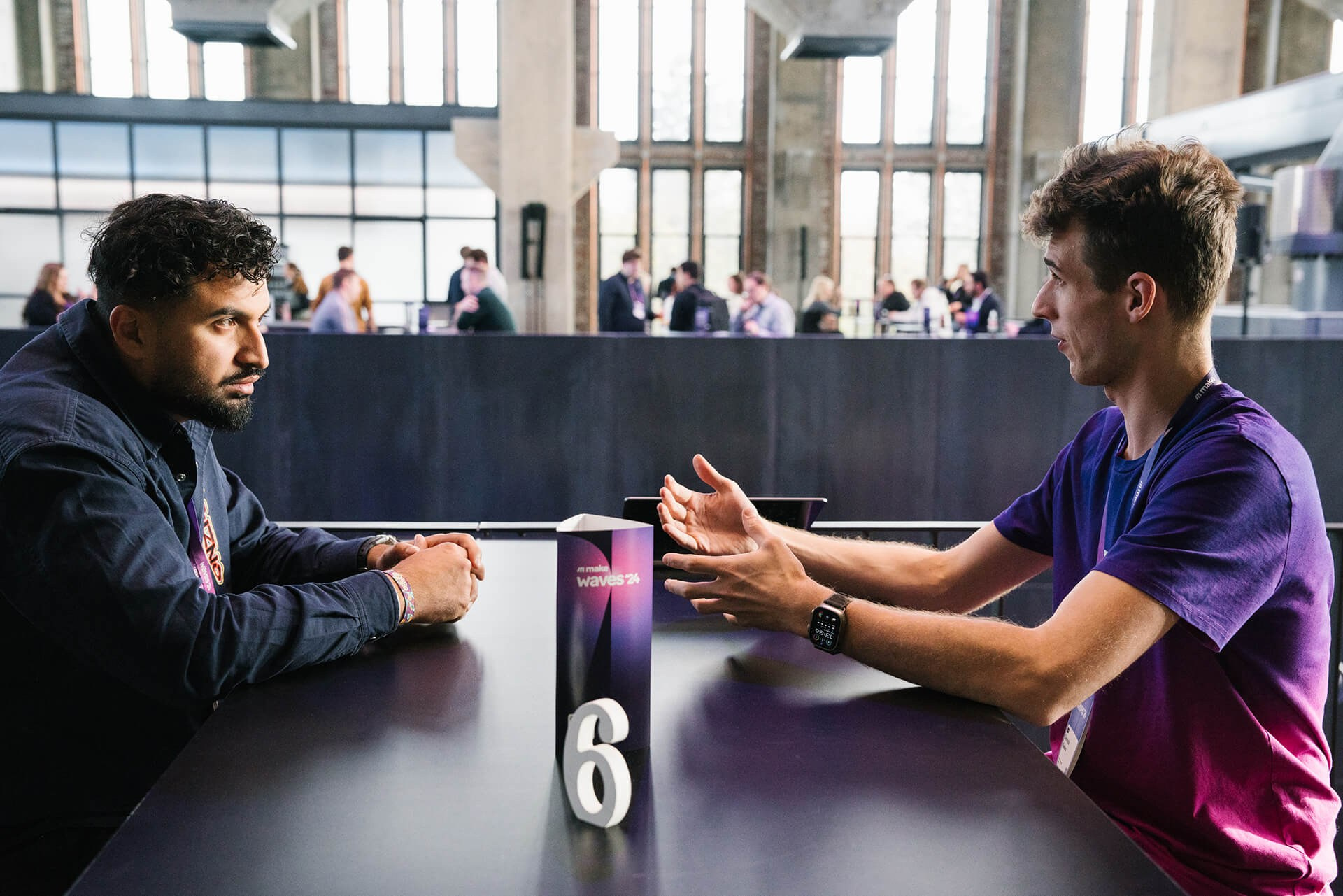 Business discussion between two men seated at a high table in a conference lounge