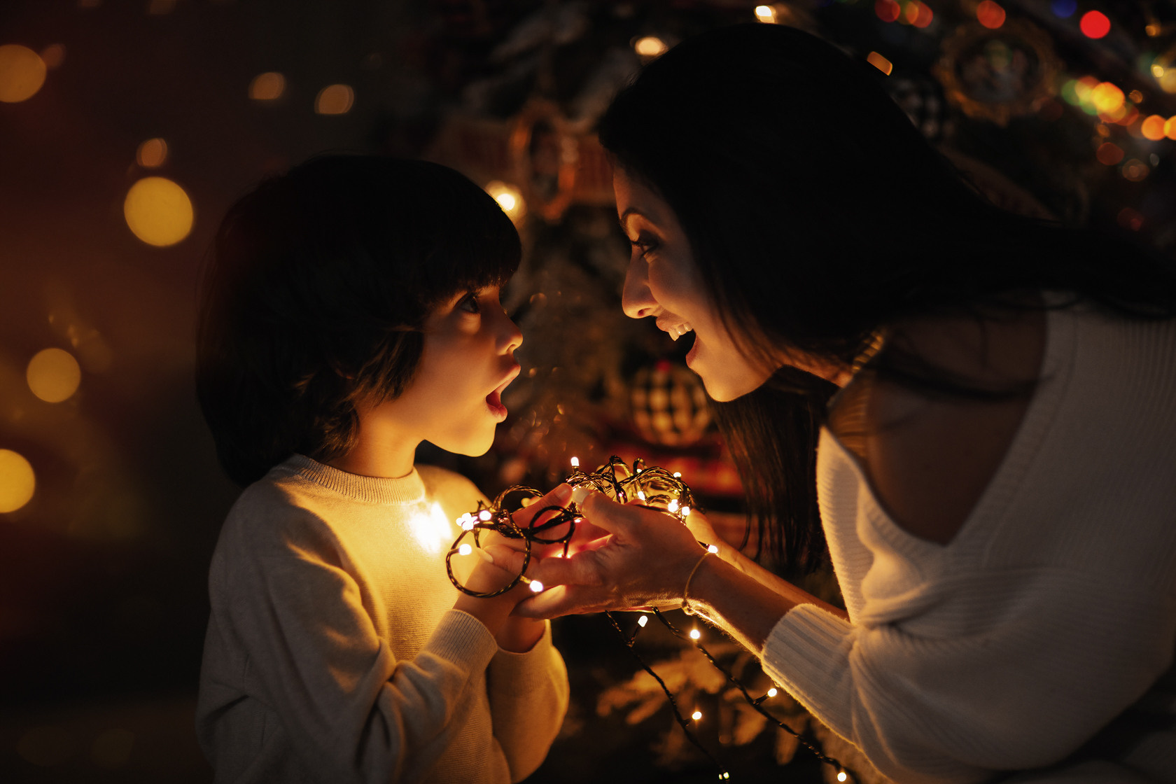 Family photo session at your home. Photographer in Shanghai - Lola Pidluskaya. Christmas shooting. Mother and son in the dark, romantic fairy-tale atmosphere