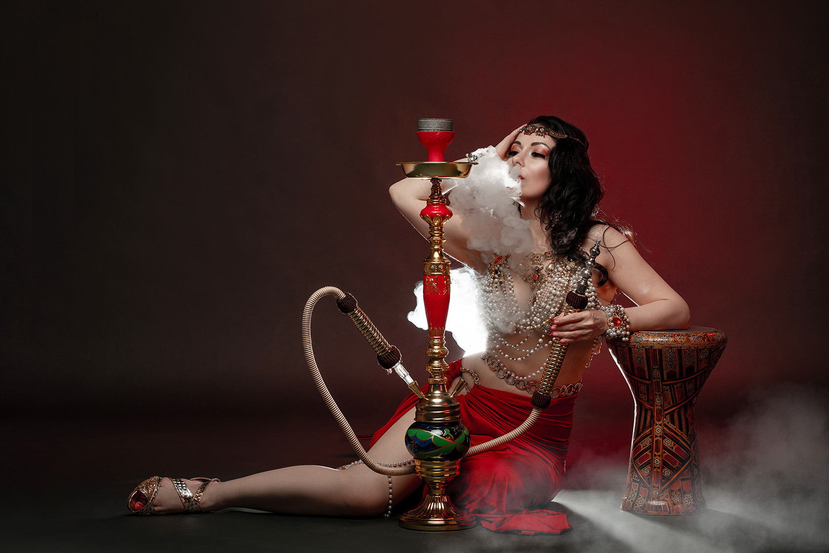 Girl smoking hookah. Dancer, belly dancing. Studio photo shoot in Shanghai