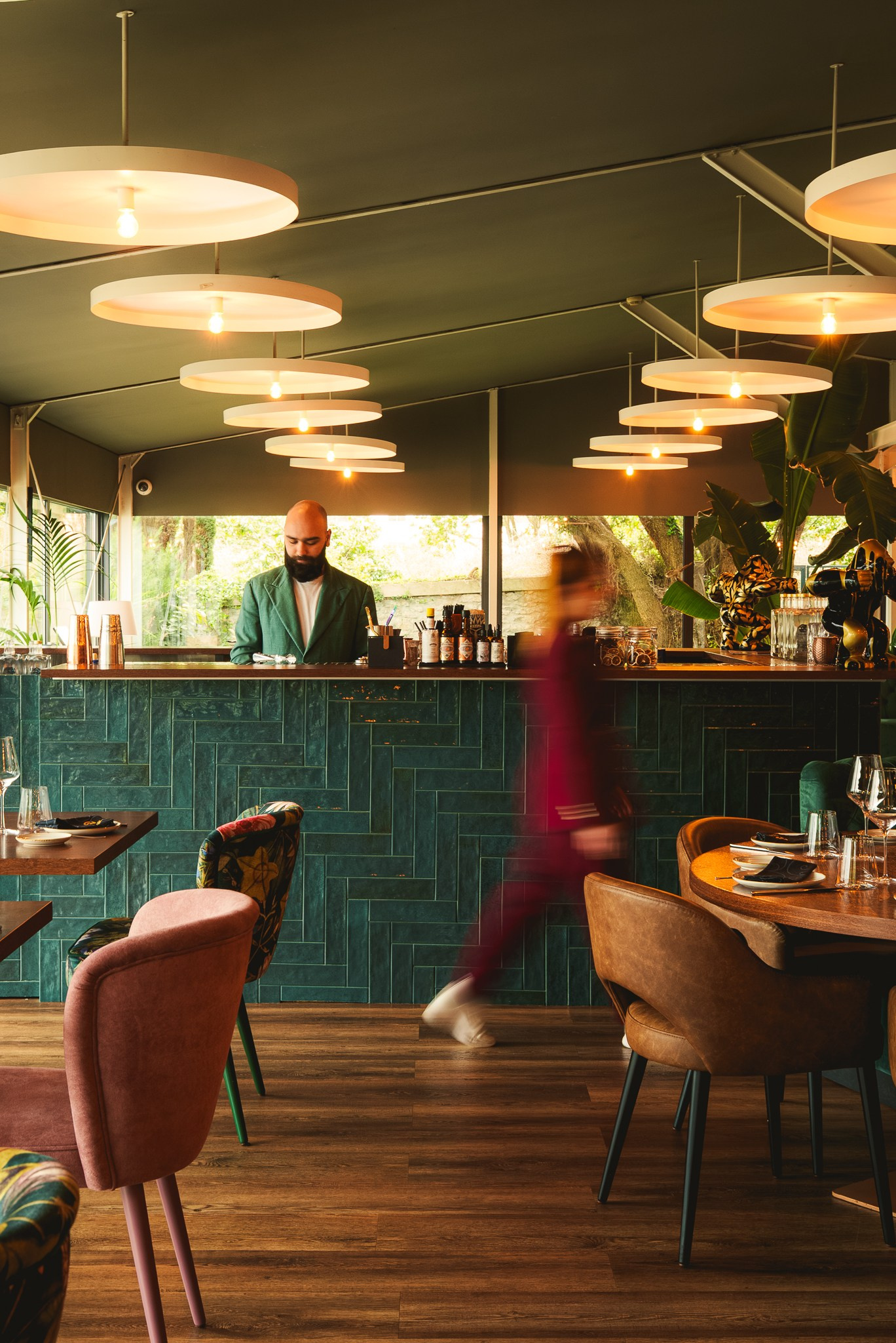 Fotografia de interiores e restauração de um bar moderno com iluminação quente e azulejos verdes, captada pela Khave Media no norte de Portugal