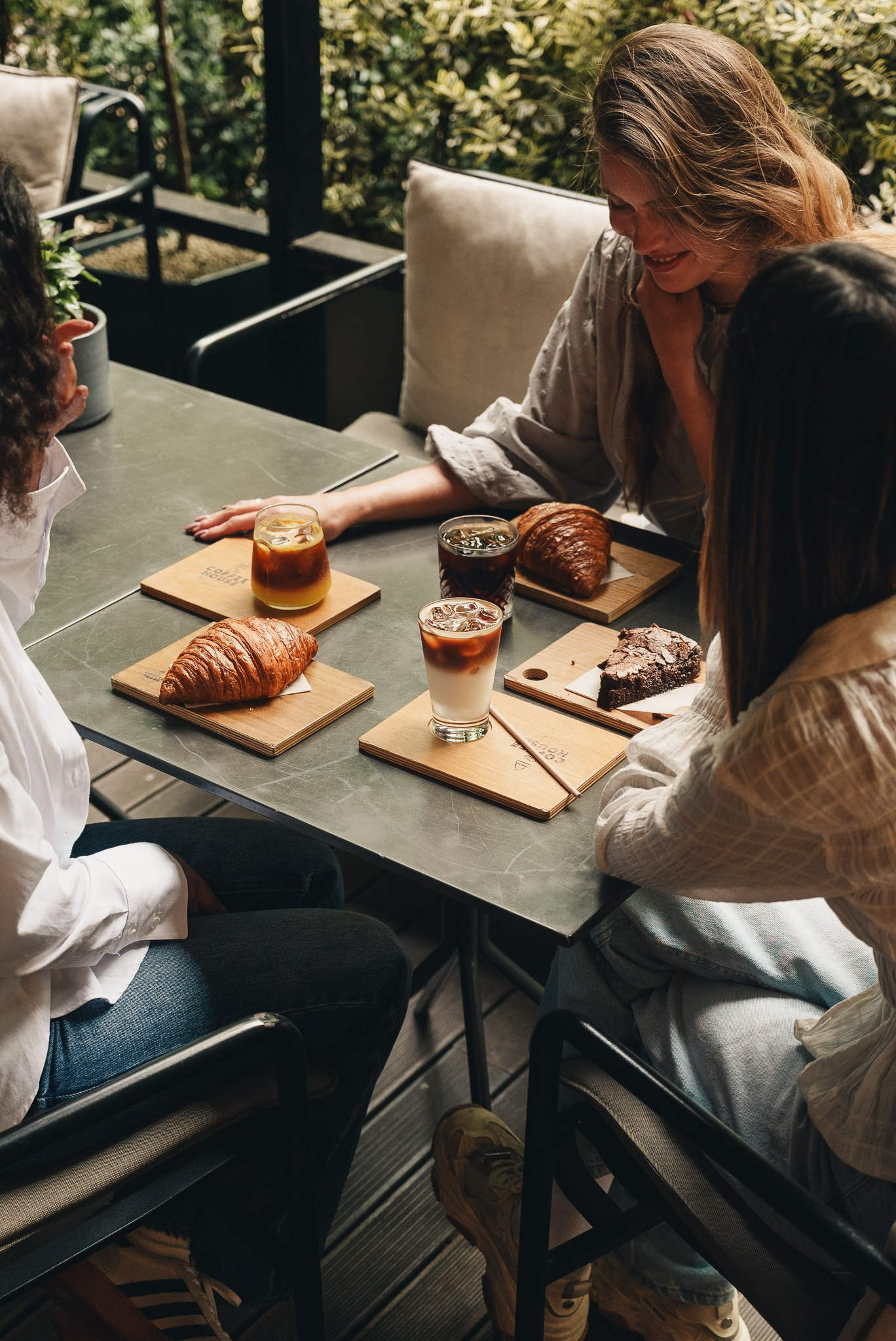 Fotografia lifestyle num ângulo de cima de um grupo de pessoas a partilhar bebidas e lanches numa mesa de esplanada, captada pela Khave Media